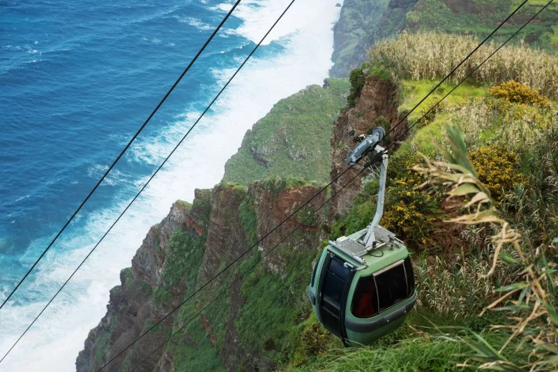 Wagonik kolejki na tle zielonego zbocza i oceanu Atlantyckiego