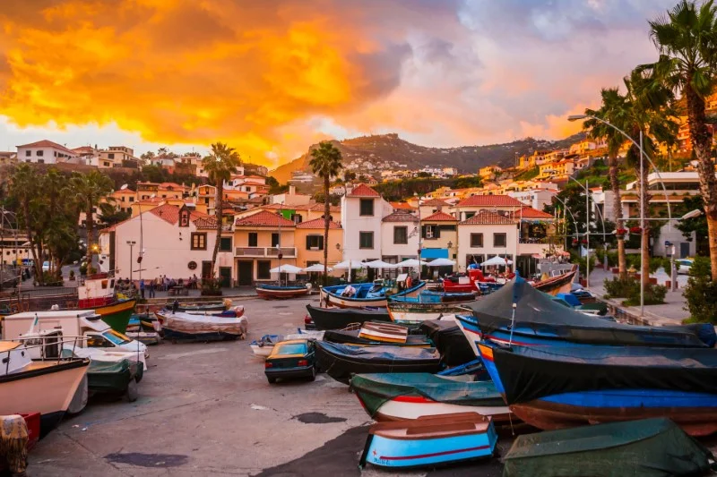 Łódki w porcie na tle zachodzącego słońca